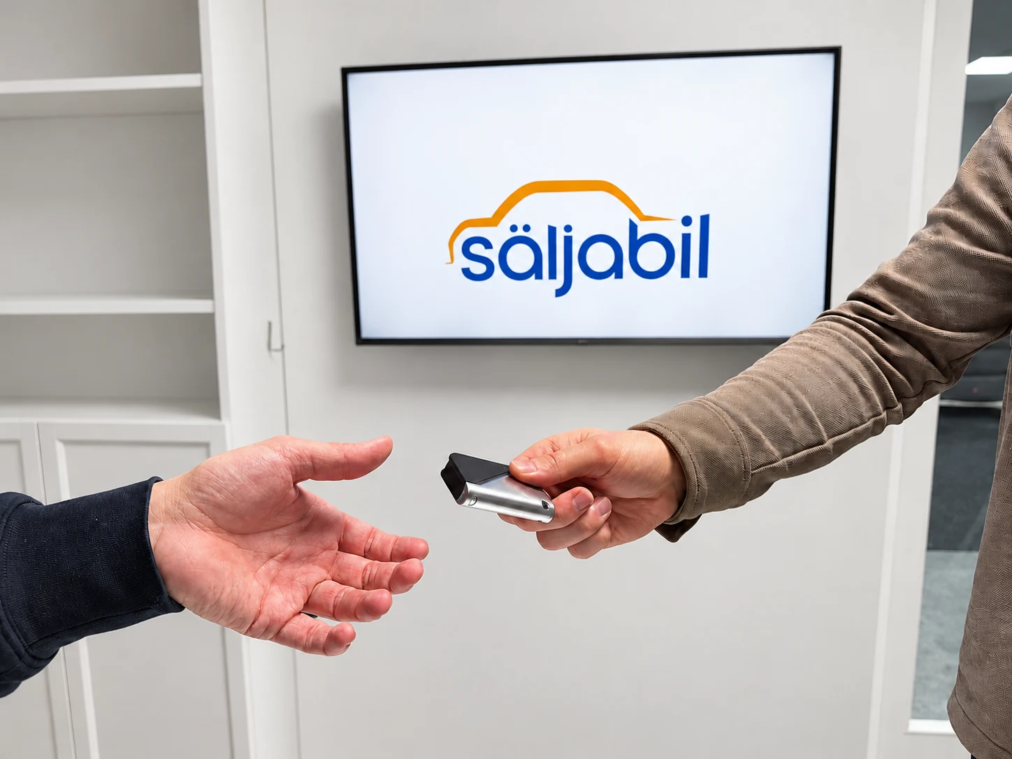En bilnyckel lämnas över framför Säljabils logotyp